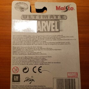 Op de afbeelding: De achterkant van een kartonnen doos met een witte achtergrond en een rood-wit-blauw Marvel-logo. De doos bevat een waarschuwing dat kleine onderdelen niet geschikt zijn voor kinderen jonger dan 3 jaar, omdat ze kunnen worden ingeslikt. De doos bevat ook een barcode, de tekst "#14254" en de tekst "Made in China".