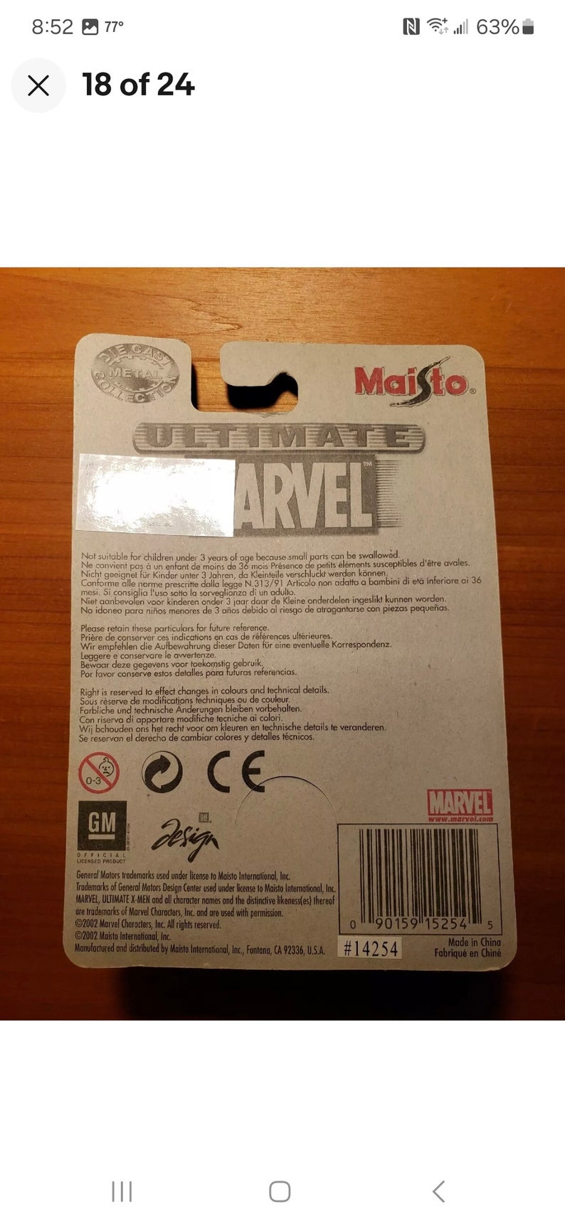 Op de afbeelding: De achterkant van een kartonnen doos met een witte achtergrond en een rood-wit-blauw Marvel-logo. De doos bevat een waarschuwing dat kleine onderdelen niet geschikt zijn voor kinderen jonger dan 3 jaar, omdat ze kunnen worden ingeslikt. De doos bevat ook een barcode, de tekst "#14254" en de tekst "Made in China".
