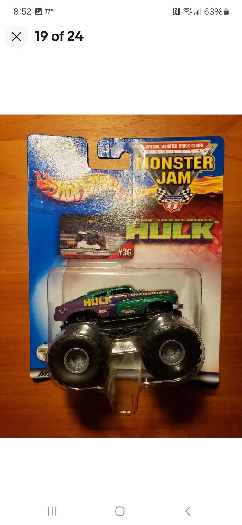Op de afbeelding: Een groen en paars monstertruck-speelgoed met de woorden "The Incredible Hulk" aan de zijkant. Het speelgoed is verpakt in een blauwe en witte kartonnen doos met de woorden "Monster Jam" en "Hot Wheels" erop. Het speelgoed is nummer 36 in de serie.