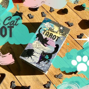 以下が含まれることがあります： 黒猫タロットデッキの箱。前面に黒猫のイラストが描かれています。箱は黒猫の置物と足跡で囲まれています。