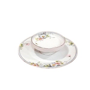 May include: A white porcelain dish with a floral design in shades of pink, yellow, and green. The dish has a smaller, matching bowl in the center.
