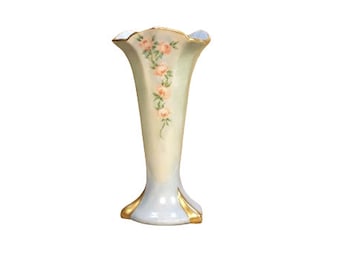 May include: A delicate, light blue porcelain vase with a scalloped rim and gold accents. The vase is decorated with a hand-painted design of pink roses and green leaves.