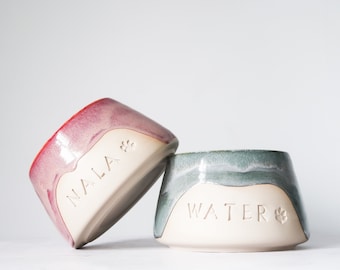 May include: Two ceramic pet bowls, one pink and one green, with the names "Nala" and "Water" inscribed on them.