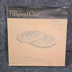 May include: A box for a Pampered Chef Microwave Chip Maker set of 2. The box is tan with a black top and features an illustration of the chip makers. The text on the box includes the product name and company information.