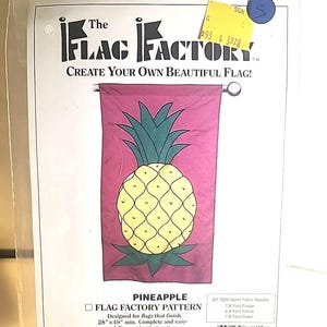 Könnte beinhalten: Ein rosa Stoff-Flaggenmuster mit einem gelben Ananas-Design. Das Muster heißt "Pineapple Flag Factory Pattern" und ist für Flaggen konzipiert, die mindestens 28" x 49" groß sind. Das Muster enthält einfache, leicht verständliche Nähanweisungen. Der Text "The Flag Factory Create Your Own Beautiful Flag!" befindet sich oben im Bild. Der Text "A Division of Mutual Industries 1400 Goldmine Rd. Monroe, NC 28110" befindet sich unten im Bild.