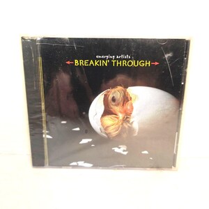 May include: A compact disc case with a black cover featuring a white egg cracking open to reveal a brown chick inside. The text "emerging artists" appears above the yellow title "BREAKIN' THROUGH" flanked by two red arrows pointing outward.
