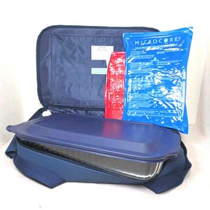 Peut inclure: Un sac isotherme bleu marine contenant un récipient alimentaire rectangulaire en métal avec un couvercle bleu foncé. À l'intérieur du sac, une poche de glace bleue Microcore et un sachet rectangulaire rouge sont placés derrière le récipient.
