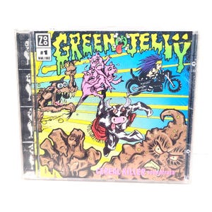 May include: A CD case featuring the album art for "Green Jellÿ #1" from March 1993. The artwork is a colorful, cartoonish illustration with various monsters, a cow, and a person riding a motorcycle. The album title and "Cereal Killer" are visible.