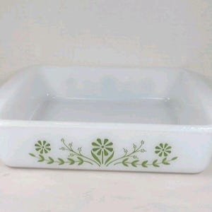 Puede incluir: Fuente de horno rectangular blanca con esquinas redondeadas. La fuente está decorada con un estampado floral verde a lo largo del borde inferior. El diseño presenta flores y hojas estilizadas. Una pieza clásica para hornear y servir.