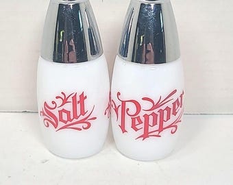 Vaso Gemco de vidrio opalino blanco con letras rojas y tapas plateadas, estilo vintage de mediados de siglo.