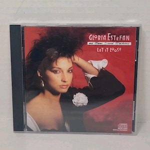 May include: CD of Gloria Estefan and Miami Sound Machine's album "Let It Loose." The cover features a woman with dark hair and a red background. The album title and artist name are printed in white. The CD is in a clear plastic case.