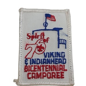May include: White embroidered patch with red, blue, and white text that reads "Spirit of '76 Viking & Indianhead Bicentennial Camporee". The patch features a blue silhouette of a flagpole with an American flag and a bench.