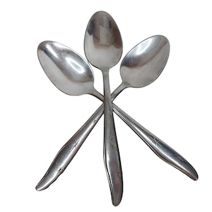 May include: Three silver spoons with a star design on the handle are arranged in a star shape.