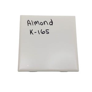May include: A white ceramic tile with the words "Almond K-165" written in black marker.