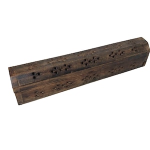 May include: A dark brown, rectangular wooden box with a hinged lid. The box features carved floral patterns along the top and sides. The wood has a natural grain and a slightly distressed appearance, suggesting a rustic or vintage style.