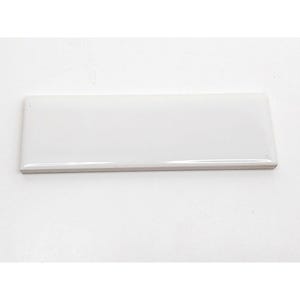 Puede incluir: Un azulejo de cerámica blanco con un acabado liso y brillante. El azulejo es de forma rectangular y tiene un borde ligeramente redondeado.