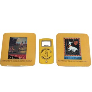 May include: Three yellow coasters with images and text. The first coaster features a cricket scene with the text "The BAT and BALL SCHWEPPES THE GREAT BRITISH BUBBLY". The second coaster is a bottle opener with the text "FAITES UN PEU DE SCHWEPPING". The third coaster features a white deer with the text "WHITE HART SCHWEPPES THE GREAT BRITISH BUBBLY."