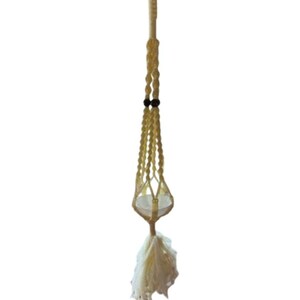 Peut inclure: Un porte-plante en macramé avec un cordon en coton blanc et des perles en bois. Le porte-plante a un pompon en bas.