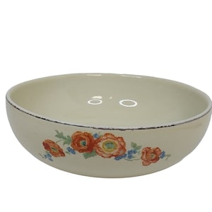 May include: Cream-colored ceramic bowl with a floral design. The bowl features a rim with a dark trim and a pattern of orange and red flowers with blue accents. The bowl is likely vintage or antique.