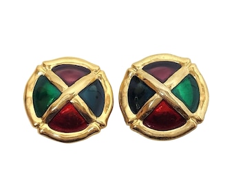 May include: A pair of gold-toned clip-on earrings. Each earring features a circular design with four colored segments: red, green, blue, and purple, separated by a gold cross. The earrings have a vintage aesthetic.