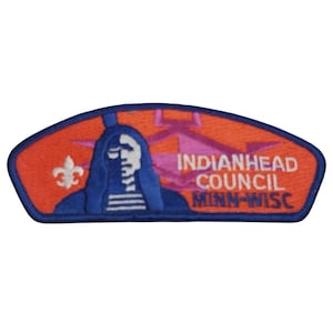 May include: A blue and orange embroidered patch with the text "Indianhead Council Minn-Wisc". The patch features a Native American profile and a fleur-de-lis.
