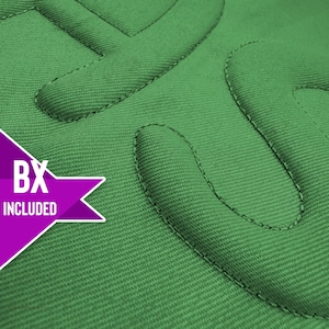 May include: Close-up of a textured, emerald green fabric with raised, stitched lettering. The letters appear to be part of a logo or design. A purple starburst graphic with the text "BX INCLUDED" is in the lower left corner.