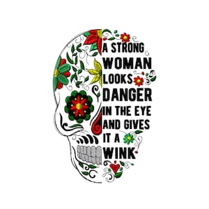 May include: A black and white illustration of a skull with floral designs. The skull has a message that reads "A strong woman looks danger in the eye and gives it a wink."