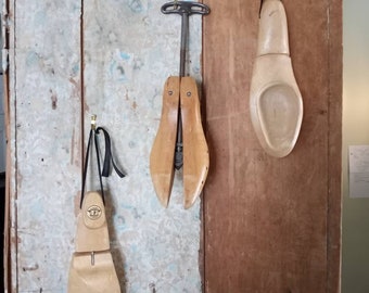 Three vintage wooden shoe forms. A pair of Florsheim size medium shoe forms and a Belcher shoe stretcher marked 0.