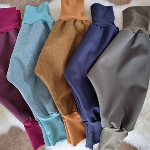 Könnte beinhalten: Fünf Paar bunte Hosen mit elastischen Bund und kontrastierenden Bündchen. Die Hosen sind aus einem weichen, dehnbaren Stoff gefertigt und in den Farben Burgunderrot, Blau, Braun, Marineblau und Grau erhältlich.