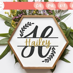 Peut inclure: Un cadre hexagonal en bois contenant une plaque blanche avec une lettre H noire en monogramme divisé et le prénom Hailey écrit en lettres dorées au centre. Le motif présente des branches feuillues noires dans les coins supérieur gauche et inférieur droit.