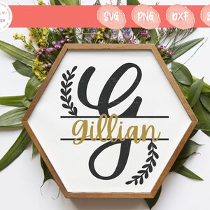 May include: A hexagonal wooden frame containing a white sign with a black letter G, a gold script name Gillian, and black leaf accents. The design features a split letter style with horizontal lines separating the name from the letter G.
