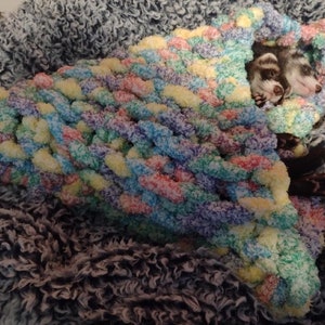 a cute hand knitted snuggle cone for small animals / ferrets hand knitted in soft thick chunky yarn in "cereal" (fruit loop colored) - great for burrowing and snuggling