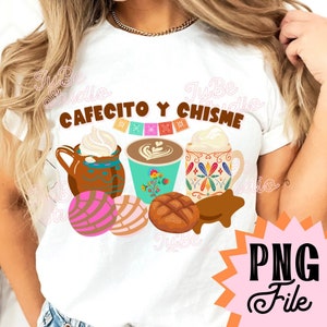 以下が含まれることがあります： 白いTシャツに、茶色の文字で「Cafecito y Chisme」と書かれています。デザインには、ホイップクリームが乗ったコーヒーカップが2つと、ラテアートが描かれたコーヒーカップが1つ、そしてカラフルなメキシコのお菓子が3つ描かれています。