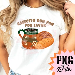 以下が含まれることがあります： 白いTシャツに、茶色の文字で「Cafecito con pan por favor」と書かれています。テキストの下には、白い花が描かれた茶色と緑のコーヒーカップと、茶色のパンが描かれています。