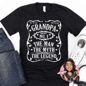 May include: Black t-shirt with white text that reads "Grandpa Best No. 1 The Man The Myth The Legend".