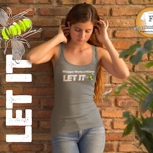 May include: A gray tank top with the text "Whisper Words of Wisdom LET IT" and a small bee graphic. The tank top is being worn by a person with long brown hair.