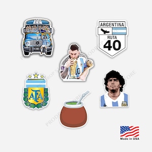 Puede incluir: Una colección de seis pegatinas que muestran un autobús de la selección argentina de fútbol, Lionel Messi besando la Copa del Mundo, una señal de tráfico Ruta 40, el escudo de la AFA con tres estrellas, un mate con bombilla y Diego Maradona.