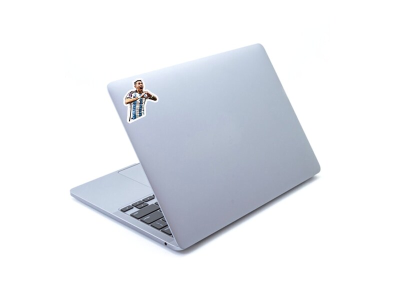May include: A silver laptop computer with a sticker of a soccer player making a heart shape with his hands.
