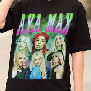 May include: Black t-shirt with a graphic print of Ava Max in a retro style. The print features multiple images of Ava Max with a pink and green "AVA MAX" text.