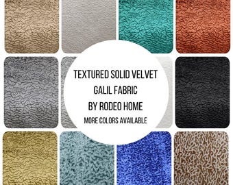 May include: A collection of textured solid velvet Galil fabric swatches by Rodeo Home in various colors including beige, white, teal, rust, gray, black, gold, blue, and brown, featuring the text: TEXTURED SOLID VELVET GALIL FABRIC BY RODEO HOME.