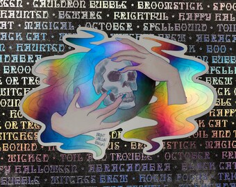 May include: A holographic sticker featuring a skull encircled by colorful, flowing lines and hands with blue fingernails. The sticker has a Halloween theme, with text in the background. The artist's name is visible.