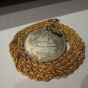 This is a 1808 Silver Plated Bermuda Replica Coin with a 18K Gold Plated Chain Necklace that measures 28 inches in length.