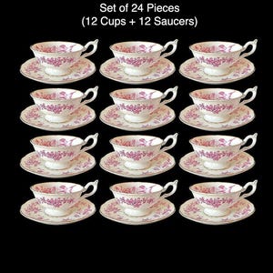 May include: A 24-piece tea set featuring white teacups and saucers with a pink floral pattern and gold edging. The text at the top reads "Set of 24 Pieces (12 Cups + 12 Saucers)".
