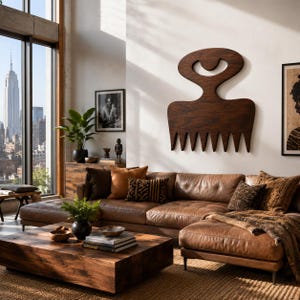 May include: A living room featuring a brown leather sofa, a wooden coffee table, and a large wooden comb-shaped wall art. The room has a large window with a city view and decorative cushions.
