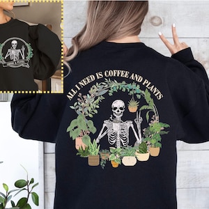 May include: Black sweatshirt with a skeleton holding a peace sign surrounded by plants and the text "All I need is coffee and plants".