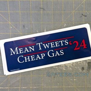May include: A blue and white sticker with the text "MEAN TWEETS '24 CHEAP GAS" and the website "2ATEES.COM".
