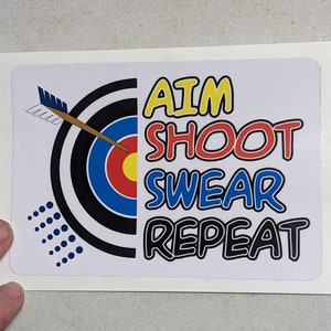 May include: White sticker with a black and white archery target, a brown arrow, and the text "AIM SHOOT SWEAR REPEAT" in colorful letters.