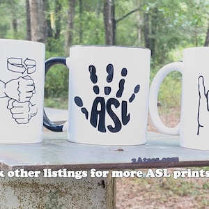 May include: Three white ceramic mugs with black handles. Each mug features a different sign language symbol in black. The first mug shows the sign for "I love you". The second mug shows the sign for "ASL". The third mug shows the sign for "love".