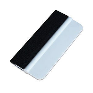 May include: A white plastic squeegee with a black felt edge. The squeegee is used for applying vinyl decals and removing air bubbles.
