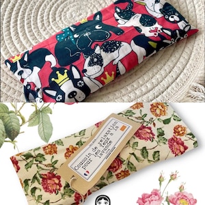 Op de afbeelding: Een rood en wit oogkussen met een bloemenpatroon en een zwart-witte hondenprint. Het kussen heeft een label met de tekst "Coussin de Relaxation pour les yeux a la lavande".